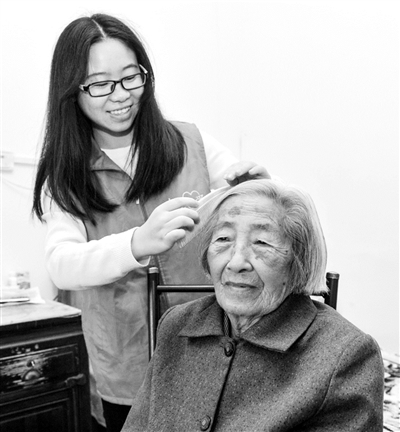 志愿者在敬老院为老人梳头.(资料图片)新华社发