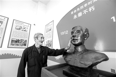 南寨村革命史展馆内,李时清烈士之子李业兴瞻仰父亲塑像.