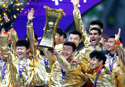 图为12月19日,山东鲁能泰山队球员在颁奖仪式上捧杯庆祝.